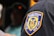 A close-up view of a patch on a uniform, reading 'Taxi and Limousine Commission City of New York' with a yellow and blue emblem showing various figures and symbols.