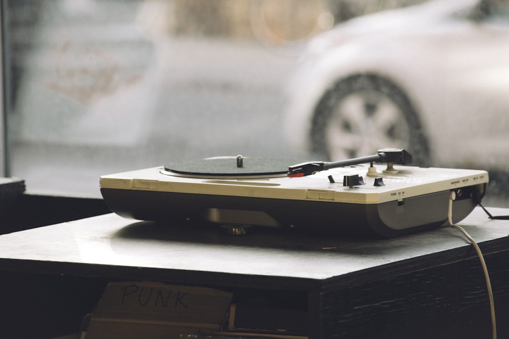 beige and black DJ turntable on black surface