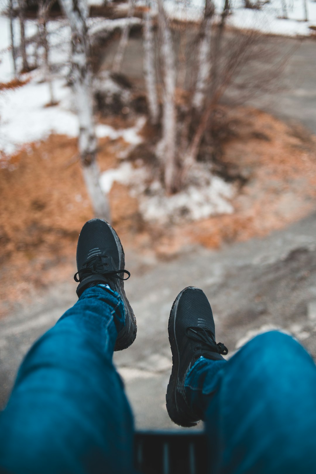 person wearing blue denim jeans and black sneakers