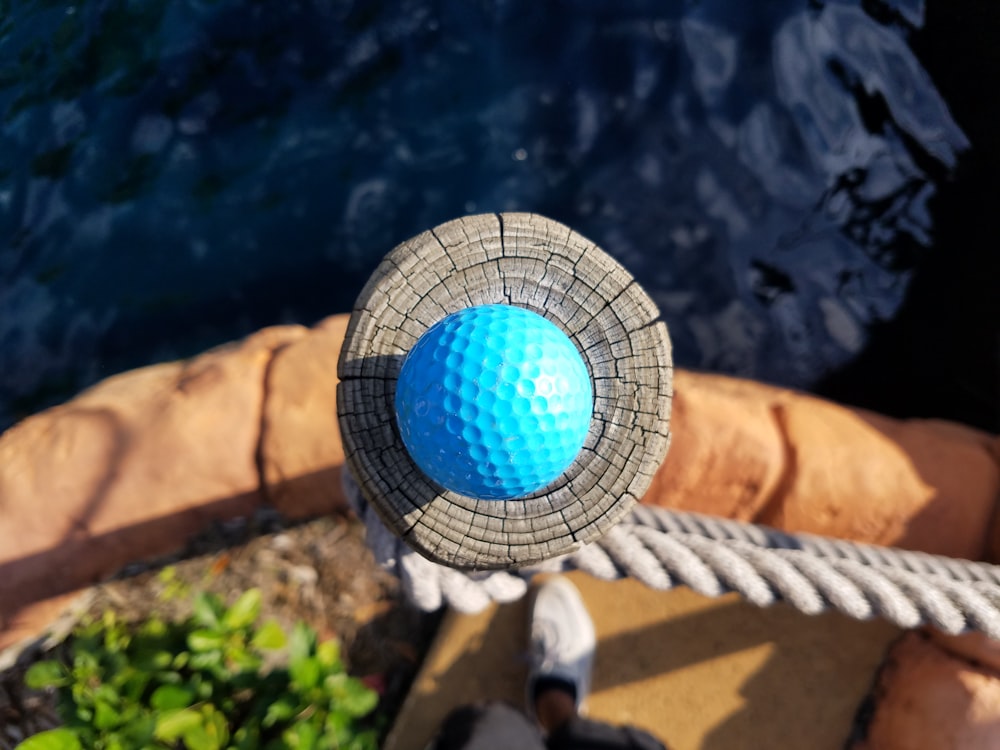 bola de golfe azul na superfície marrom