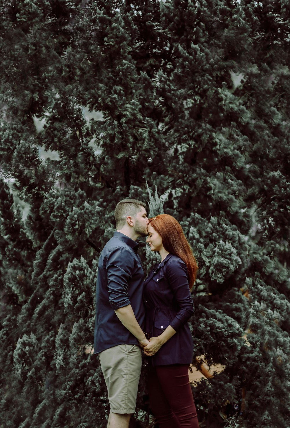 man kissing woman's forehead