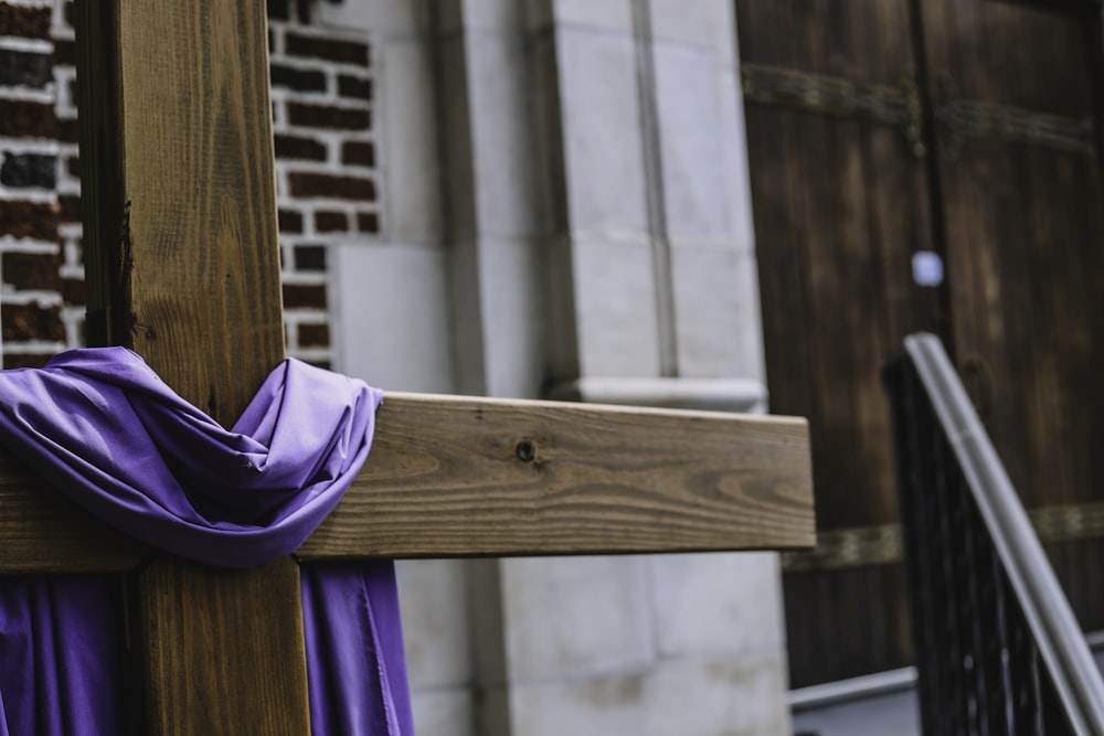 purple textile on brown woodrn cross