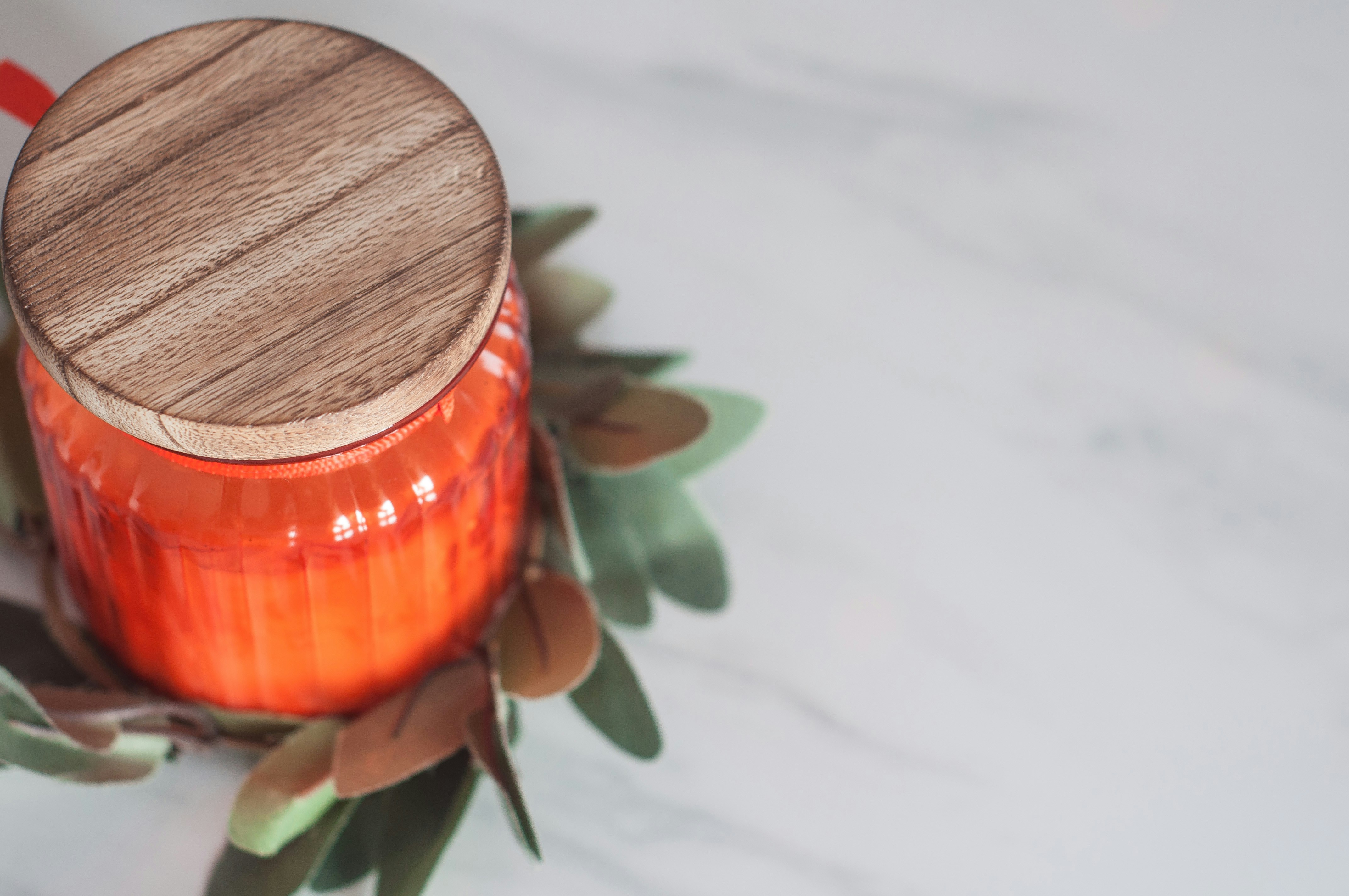 orange glass bottle with lid on table