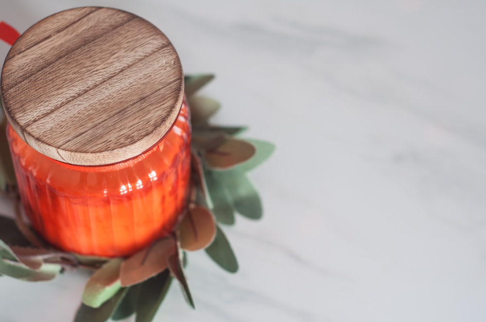 orange glass bottle with lid on table