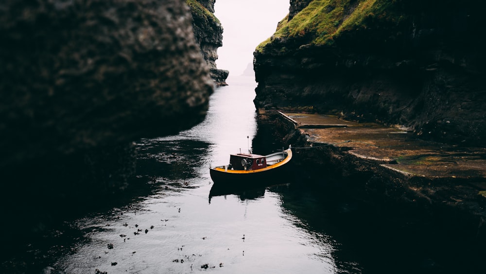 boat on water between rock formations