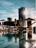 A modern urban setting with a rooftop pool surrounded by lounge chairs and umbrellas. High-rise buildings can be seen in the background, and the sun is casting reflections on the water, creating a serene and luxurious atmosphere.