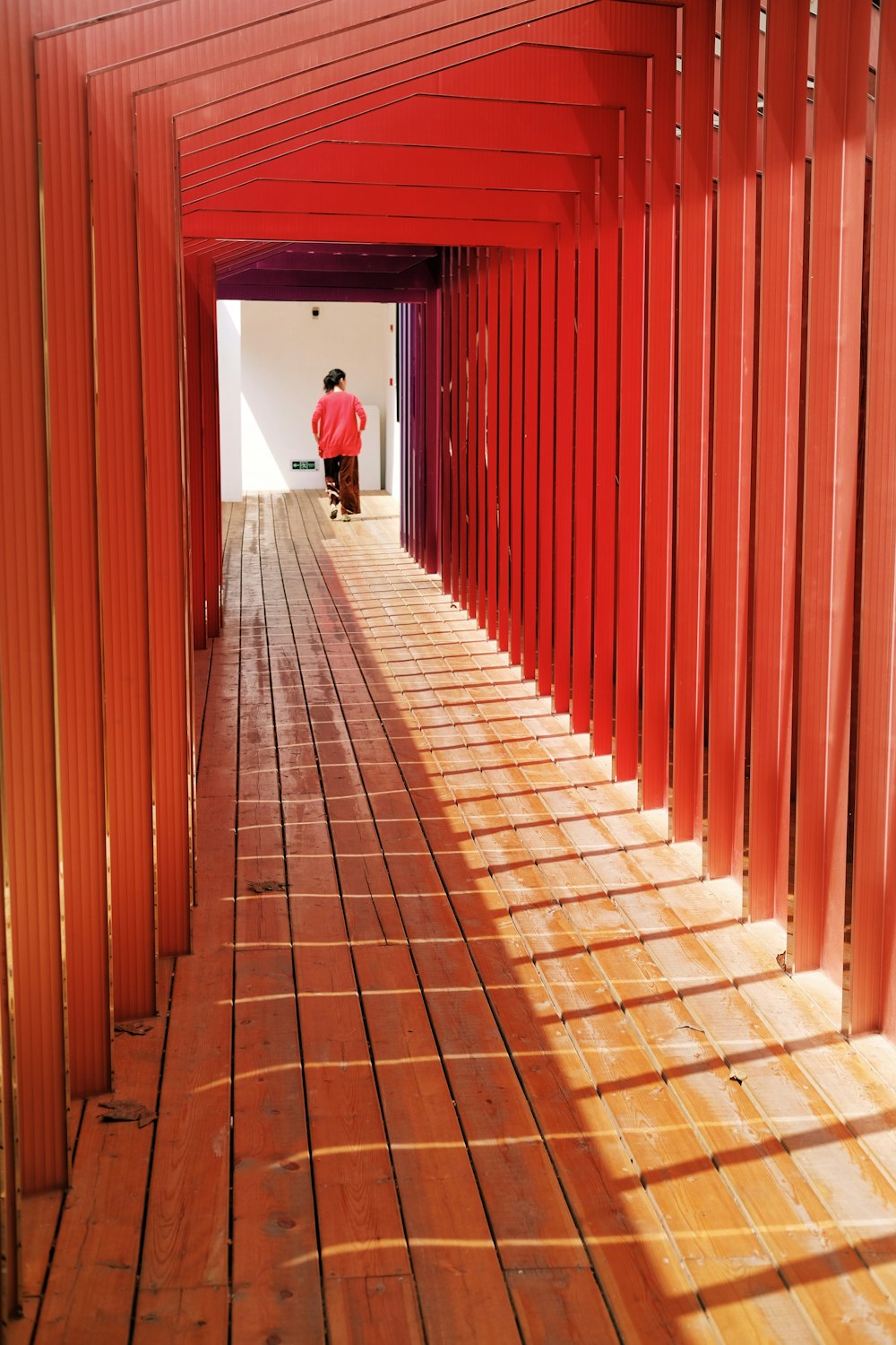 woman walking between wooden walls