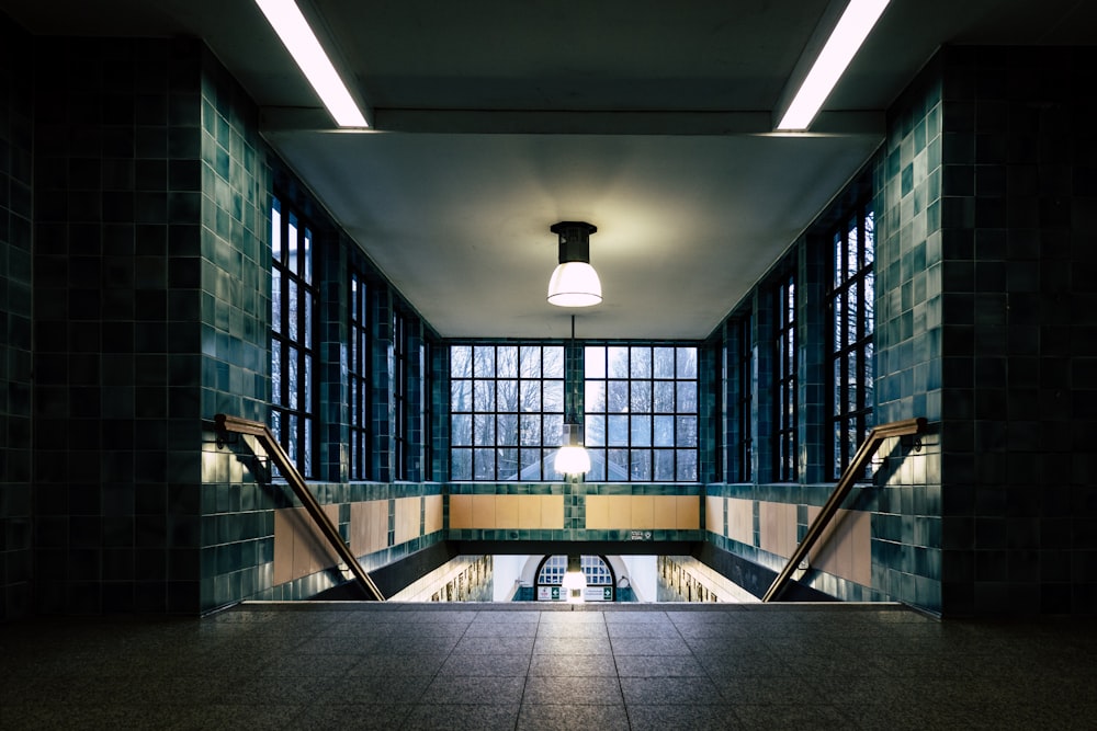 a long hallway with tiled walls and windows