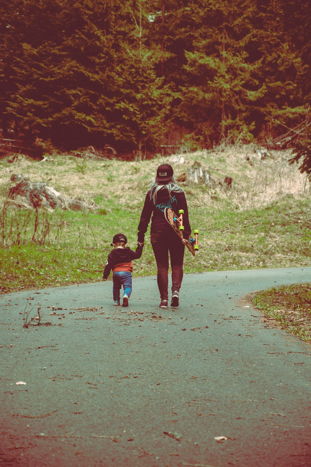 adult and toddler walking on road