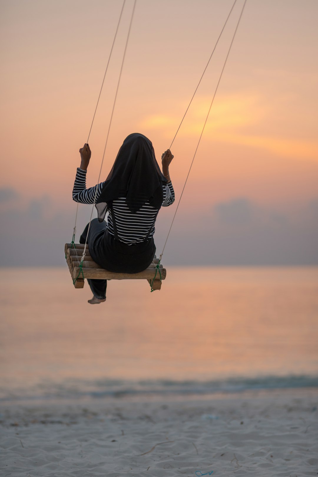 woman swinging on seashore