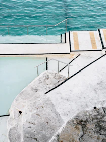 Inviting pool area with turquoise water and natural stone surroundings.