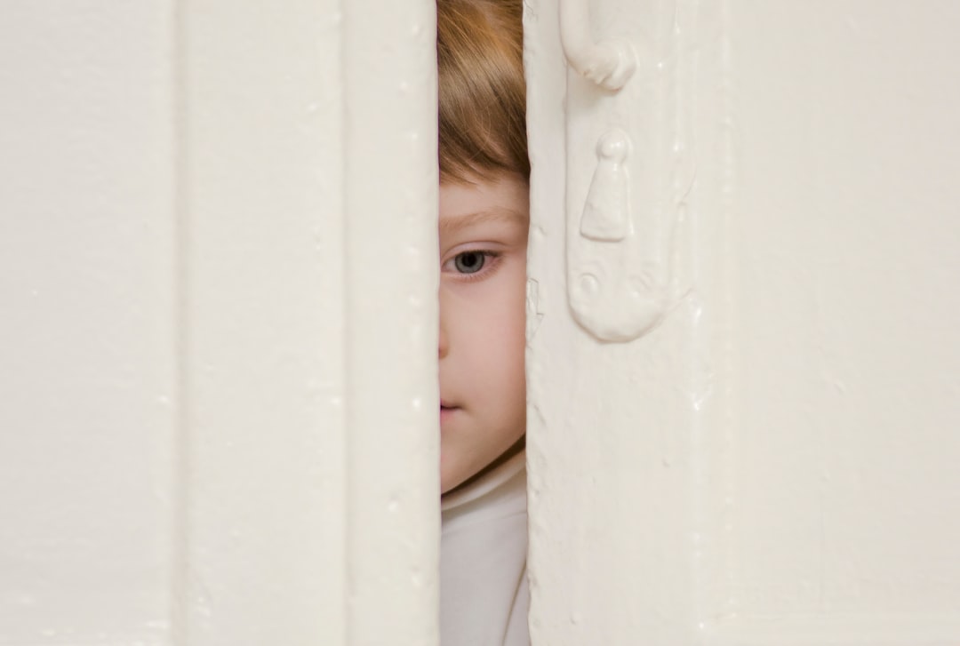 boy looking behind door