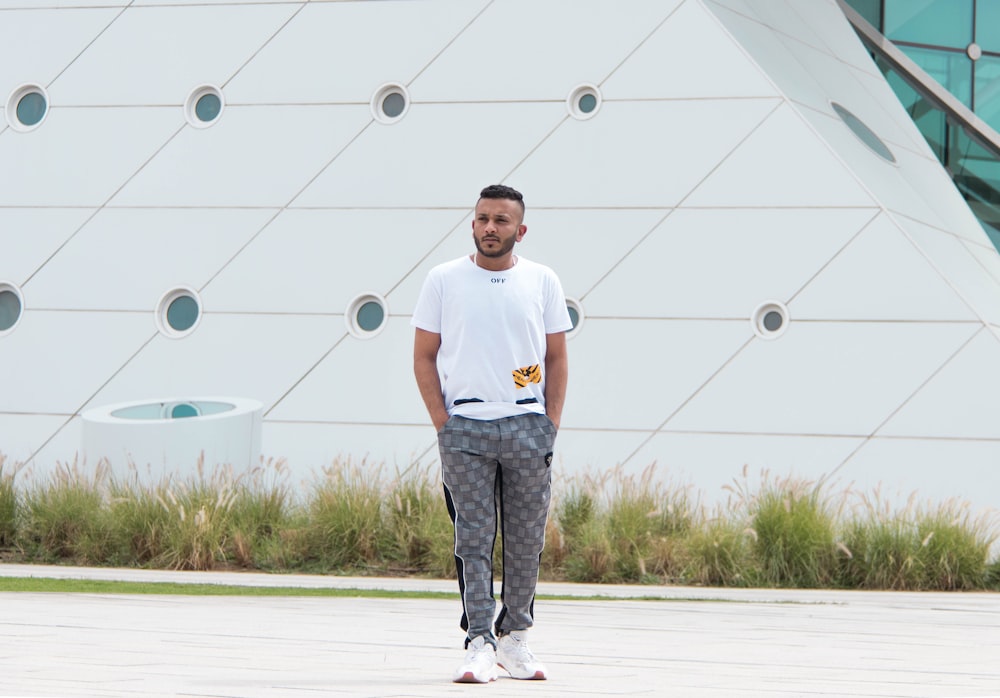 man standing on road near building