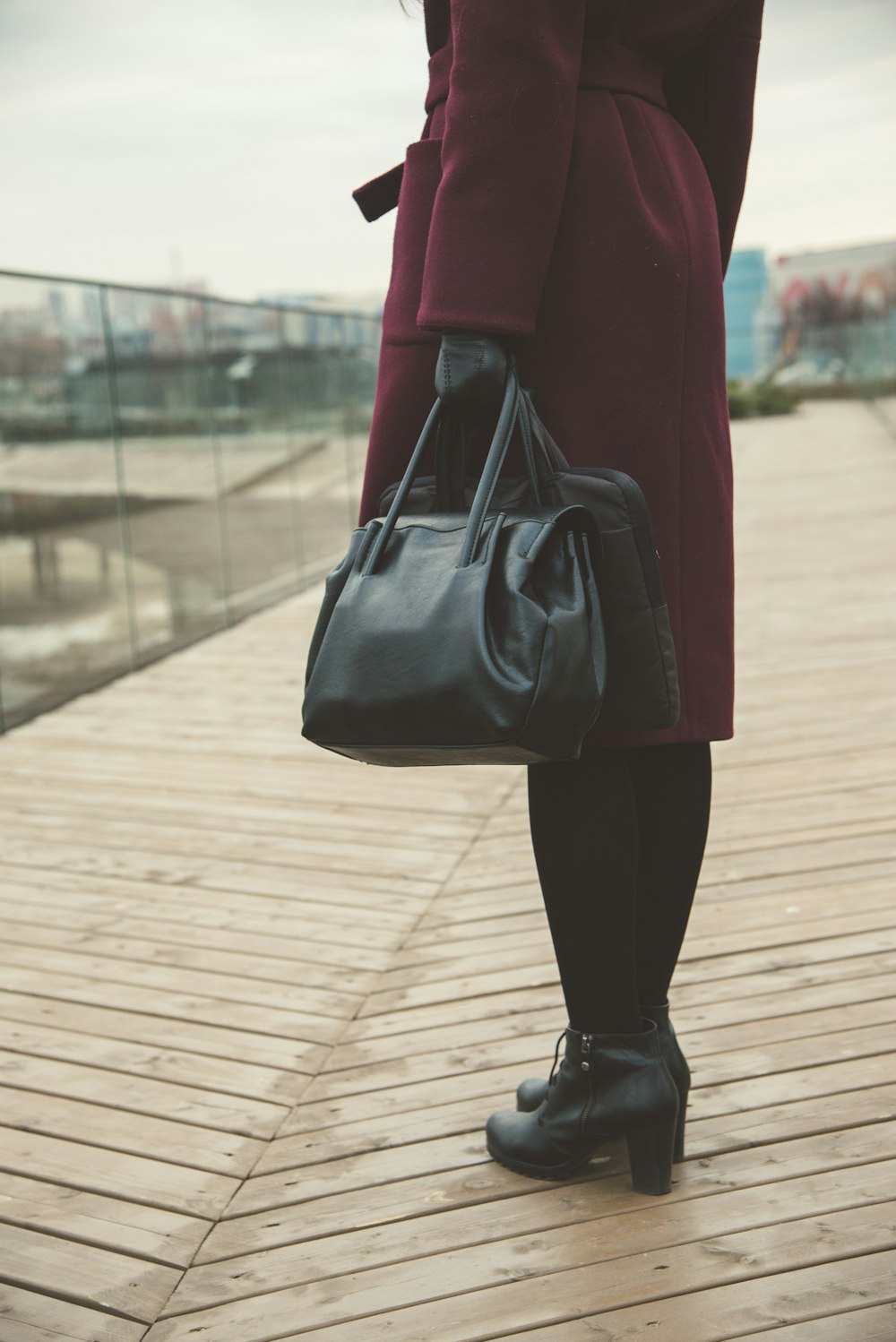 Frau steht und hält schwarze Taschen in der Hand