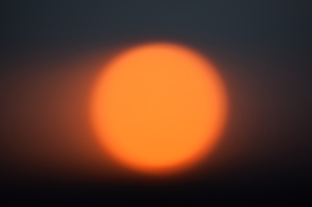 Une boule de lumière orange vif dans le ciel sombre