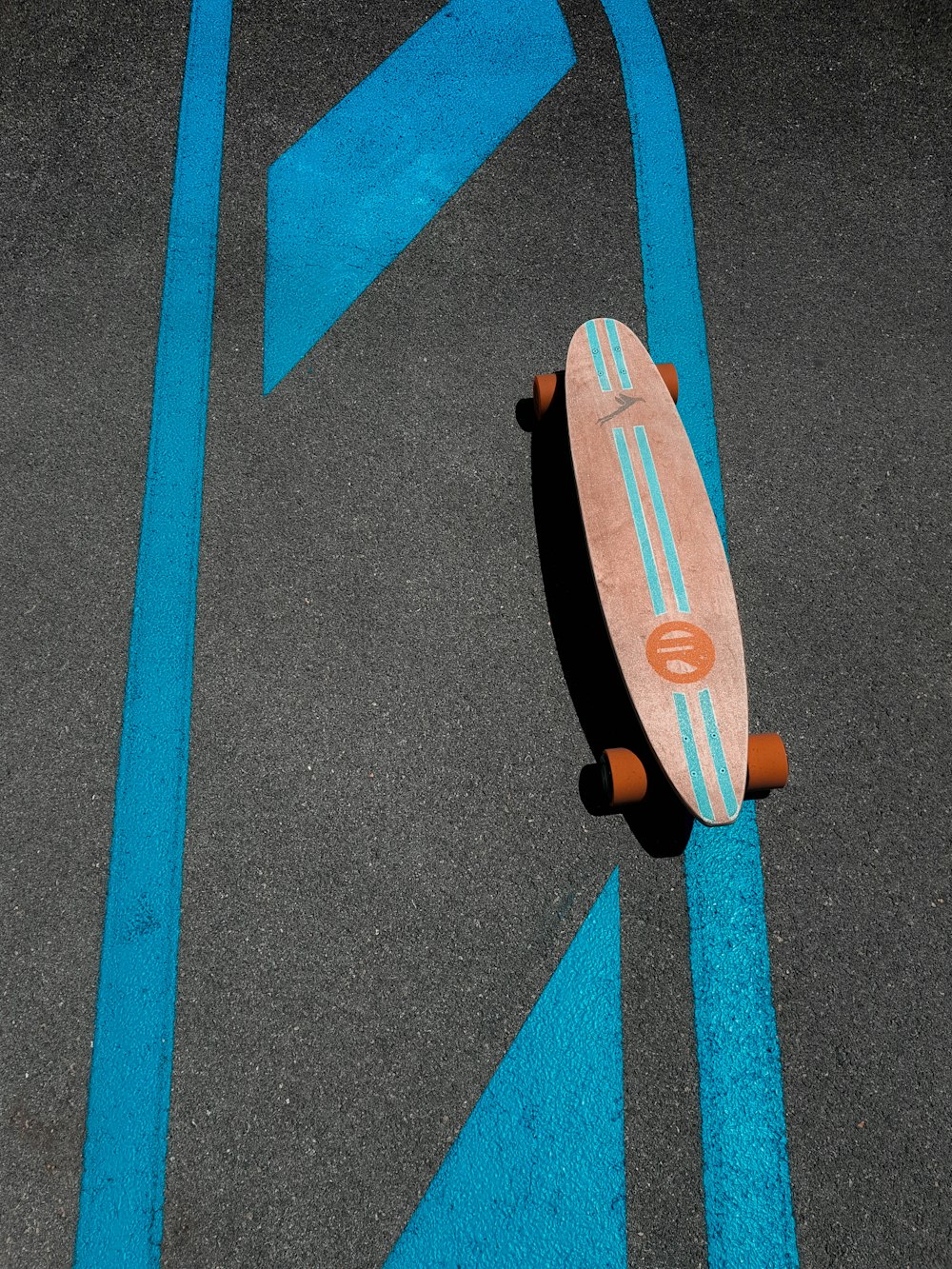 skateboard marrone e arancione su strada di cemento grigio