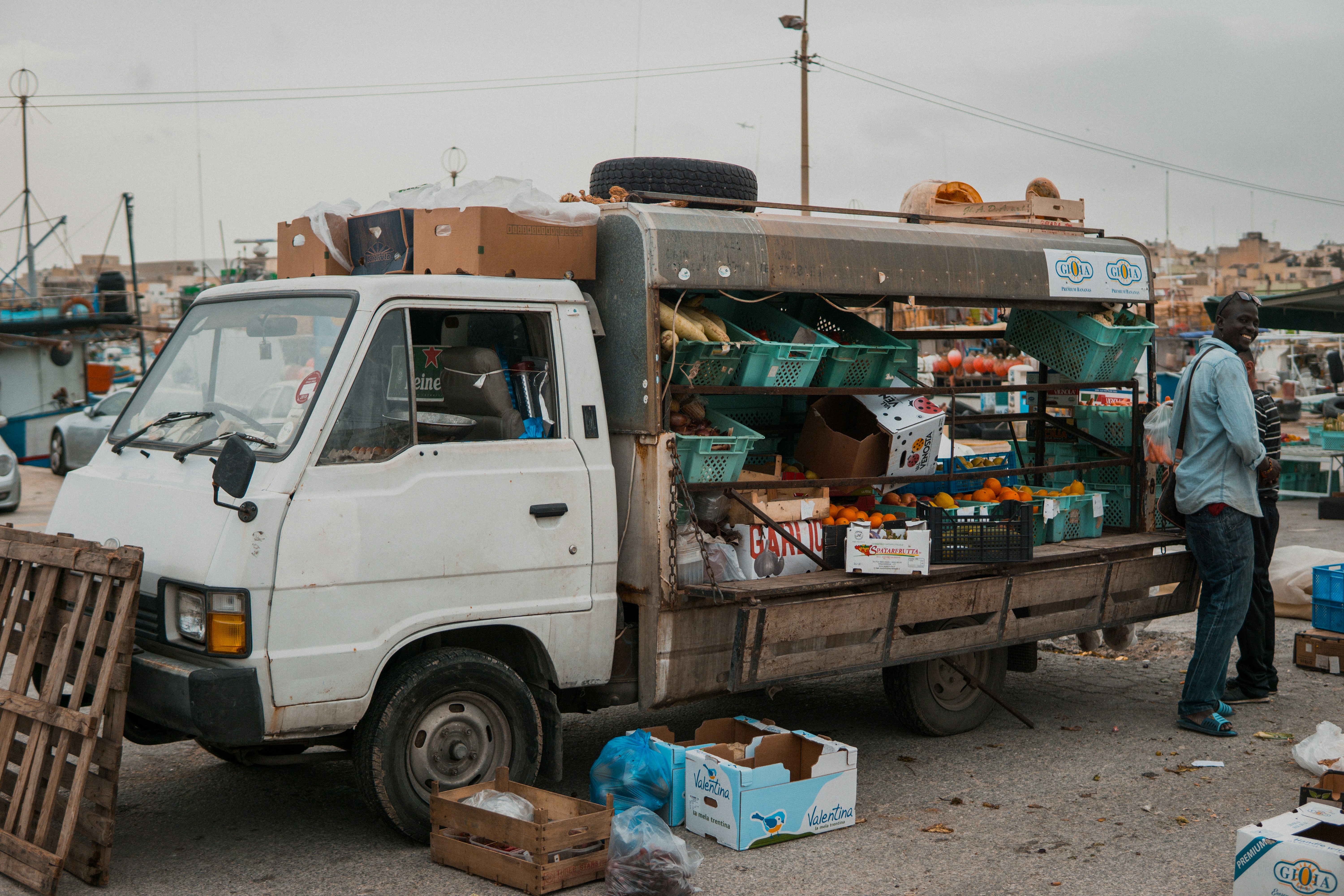 white vehicle parked beside person standing near fruit baskets
