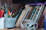 A colorful collection of left-handed mugs and notebooks arranged on a cozy shelf.