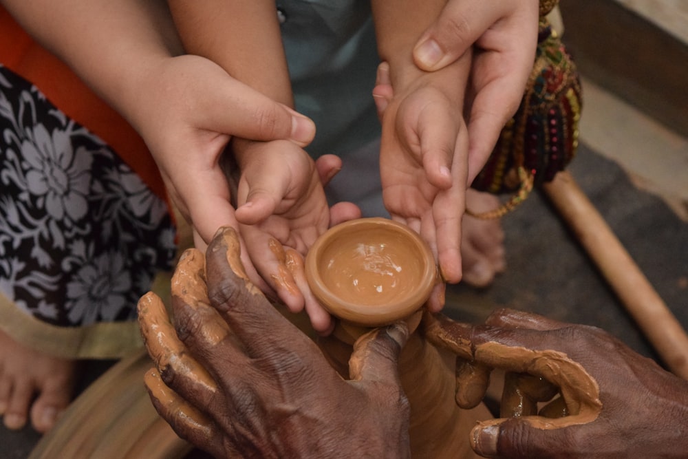 woman holding child's hand towards jar