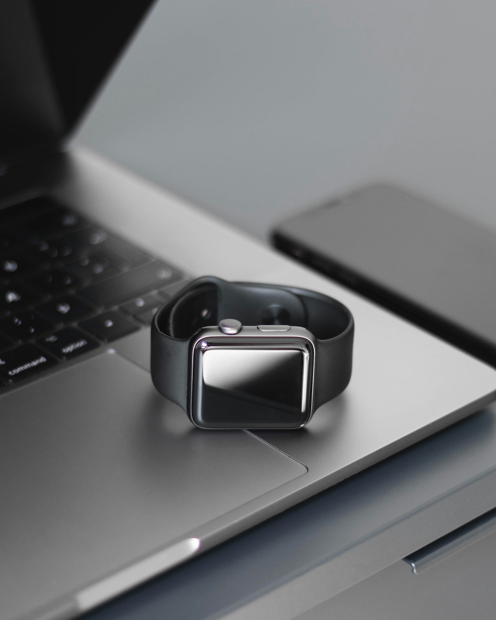 Silberne Smartwatch auf silbernem Laptop