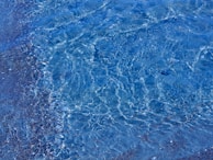 Close-up of crystal-clear water gently rippling over smooth sand in a custom aquatic design.