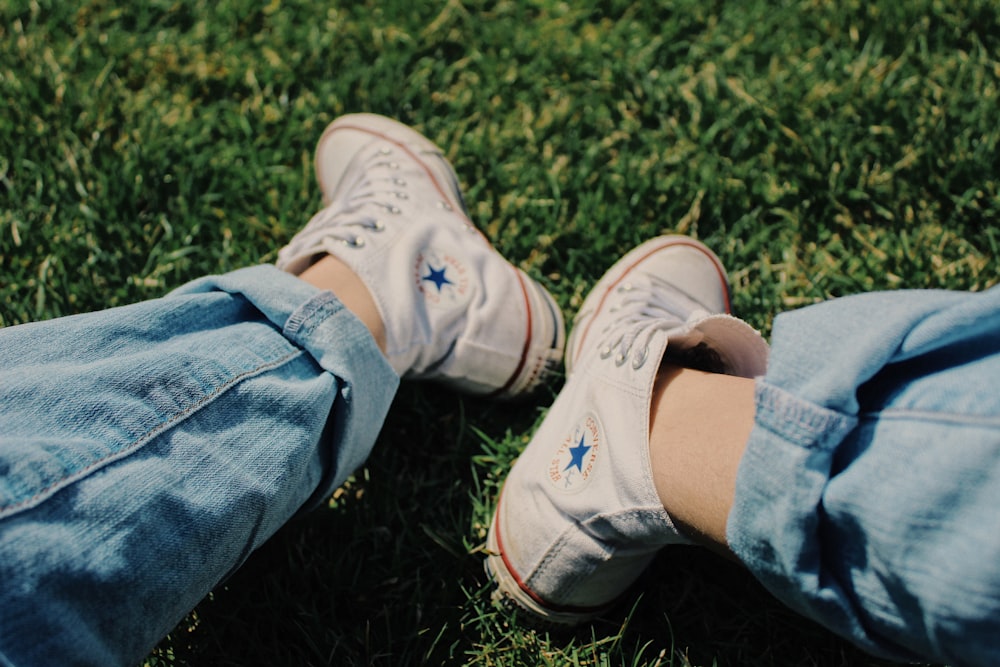 persona che indossa scarpe da ginnastica alte Converse bianche