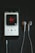 A smartphone displays a music player app with the song 'Gfy' by Dennis Lloyd from the 'Exident - EP' album. The album cover shows a red bird on a black background. White earphones are placed next to the phone on a dark wooden surface.