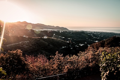 Sunset view over a spacious lot with natural vegetation and distant mountains.
