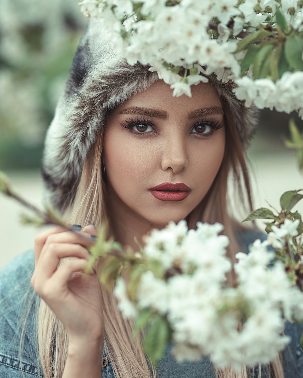 mulher em pé na frente da flor branca