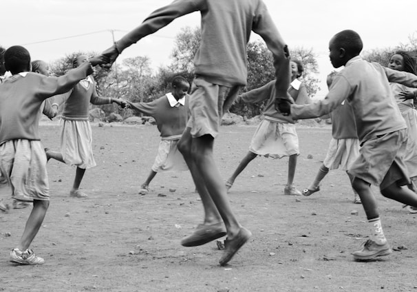 grayscale photography of people playing outside