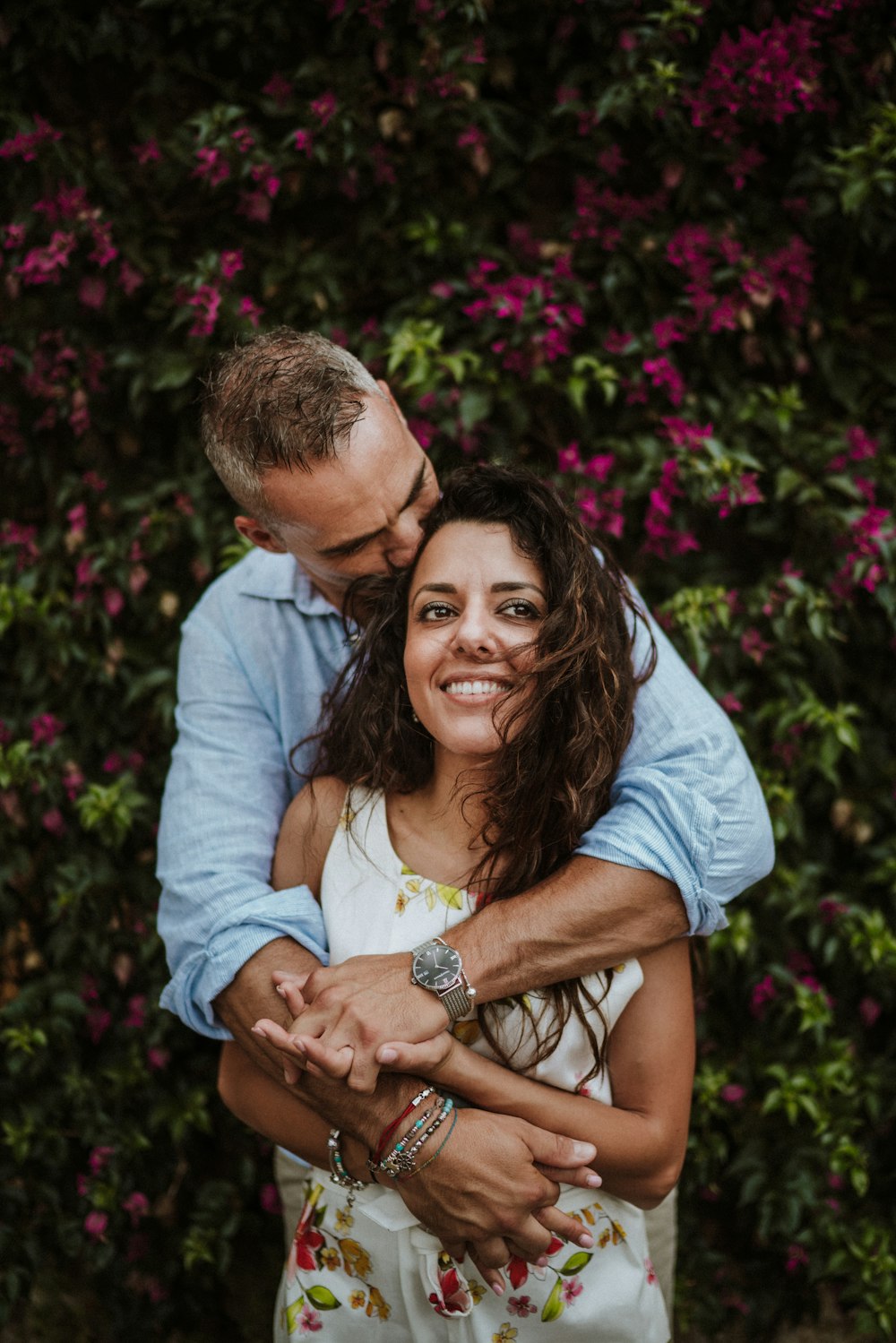 man hugging woman near plants