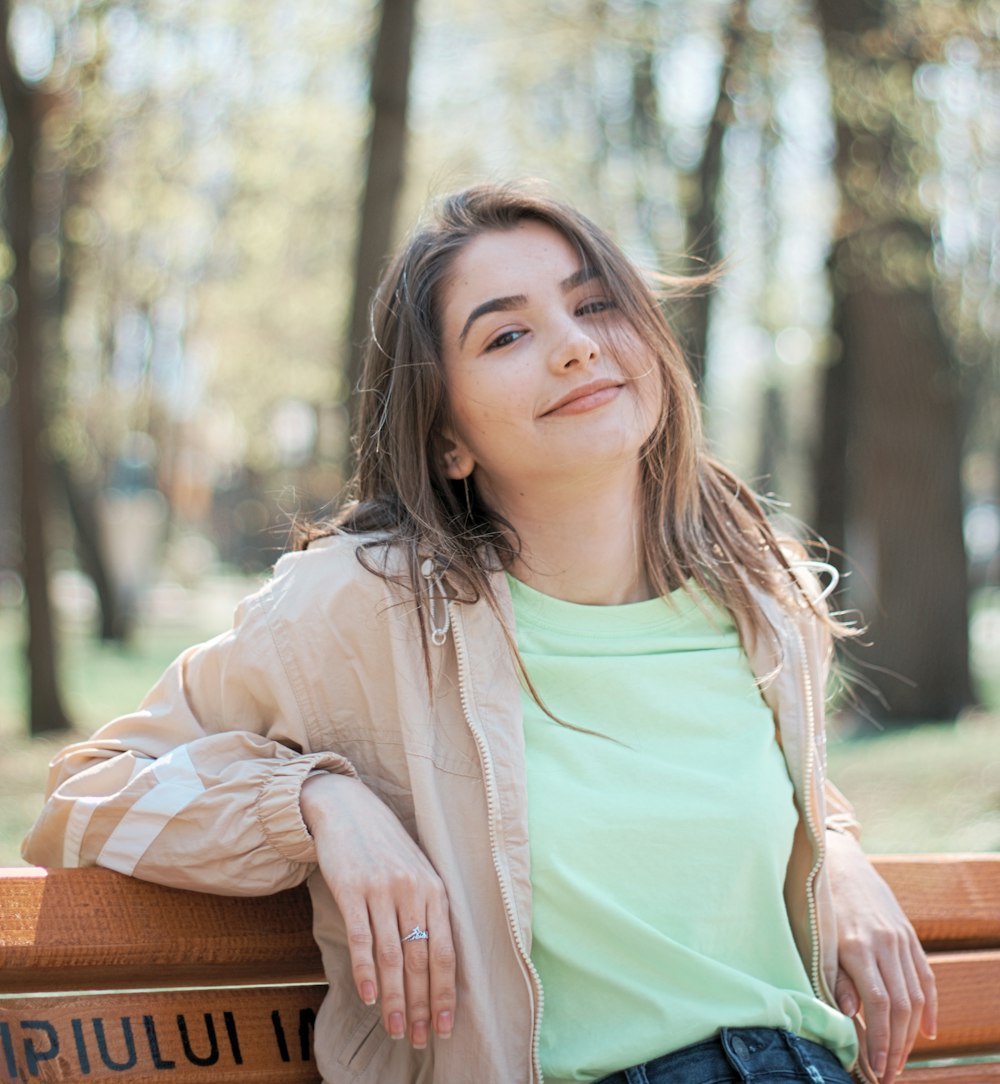 woman wearing beige zip-up jacket and green shirt