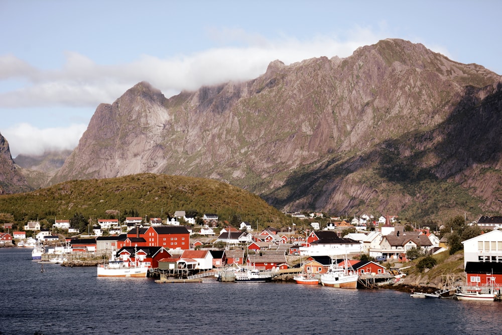 a view of a town on the water with mountains in the background