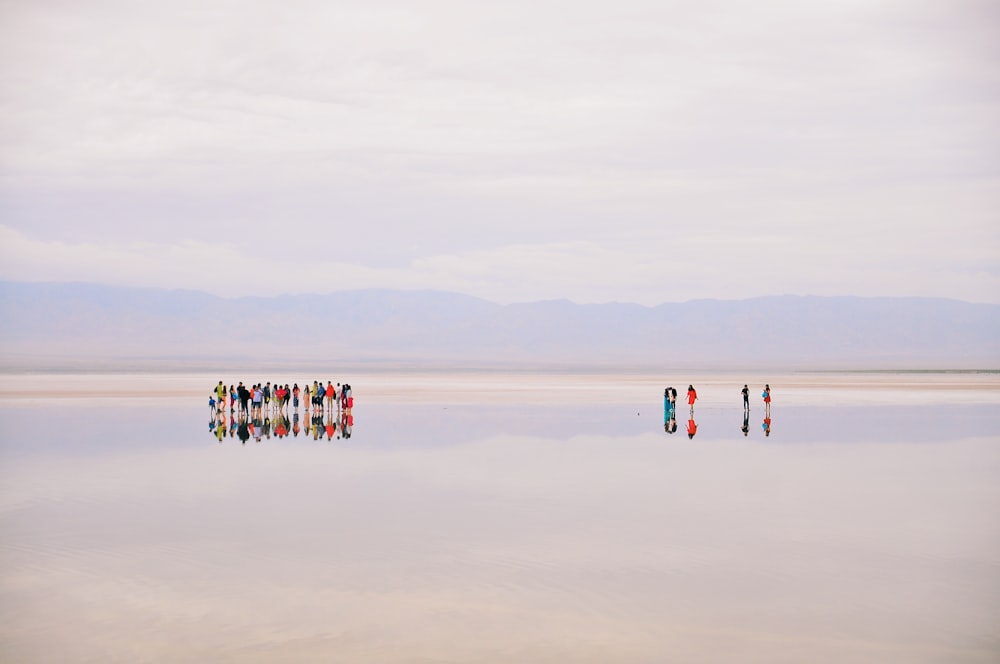 a group of people standing on top of a large body of water