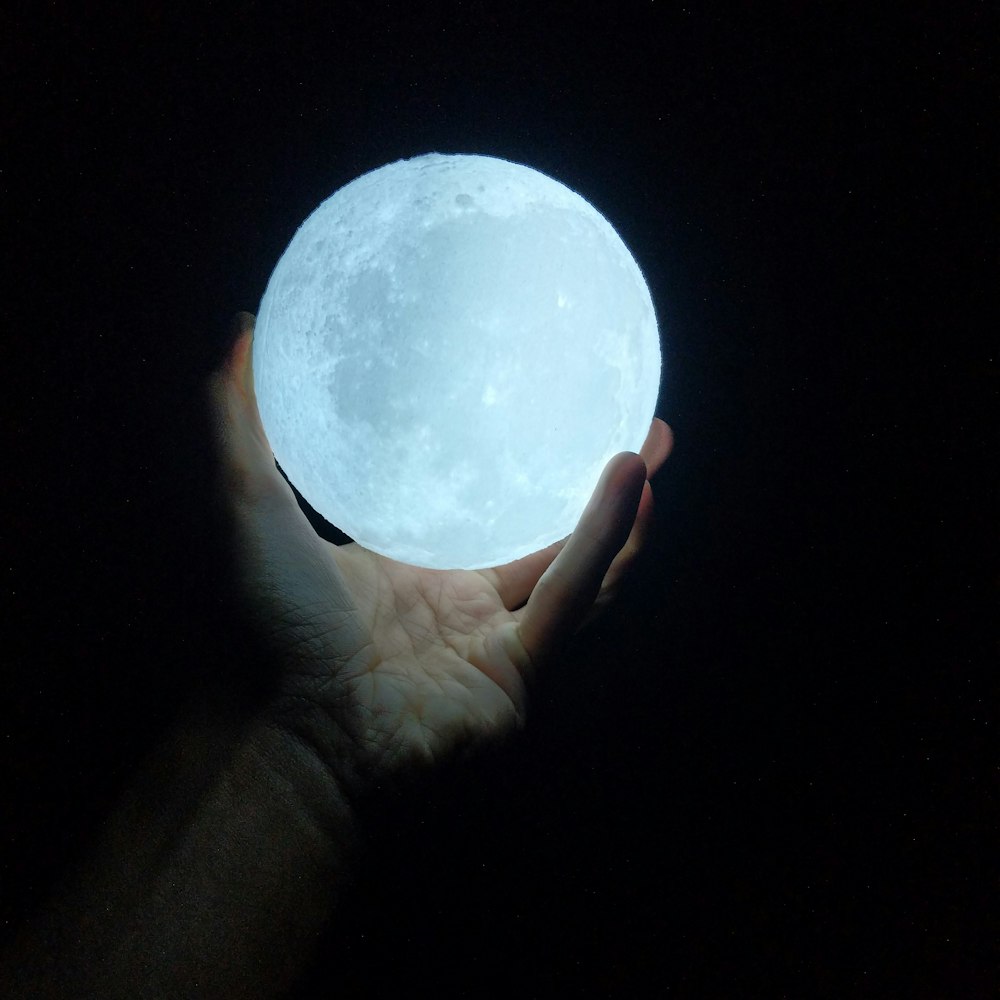 person holding glow-in-the-dark ball
