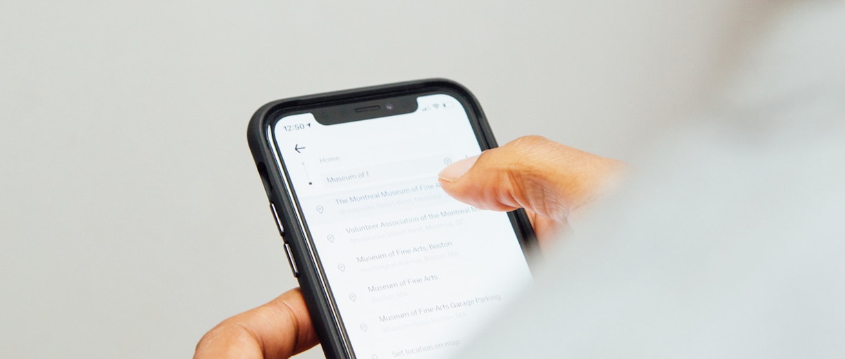 man in white top holding iPhone