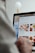 A person is using a laptop, navigating through the Uber Eats food delivery website. The screen displays various food items available for delivery in Montreal, QC, including options like McDonald's and Thai Express. The person appears to be browsing with their hand near the trackpad.