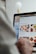A person is using a laptop, navigating through the Uber Eats food delivery website. The screen displays various food items available for delivery in Montreal, QC, including options like McDonald's and Thai Express. The person appears to be browsing with their hand near the trackpad.