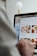 A person is using a laptop, navigating through the Uber Eats food delivery website. The screen displays various food items available for delivery in Montreal, QC, including options like McDonald's and Thai Express. The person appears to be browsing with their hand near the trackpad.