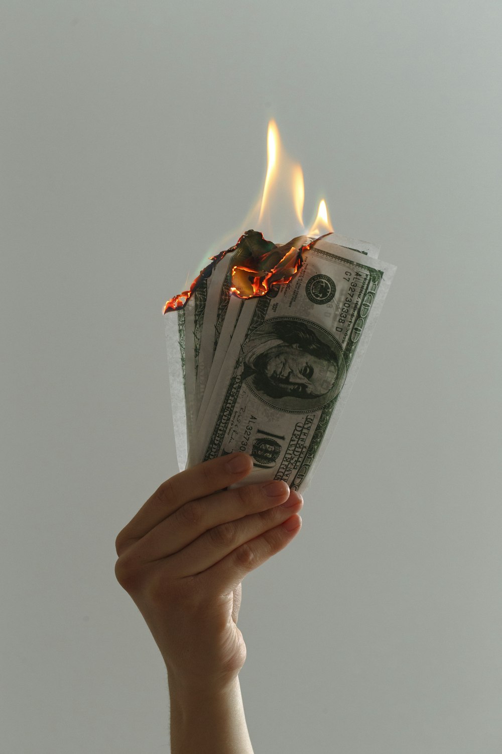 time lapse photography of several burning US dollar banknotes