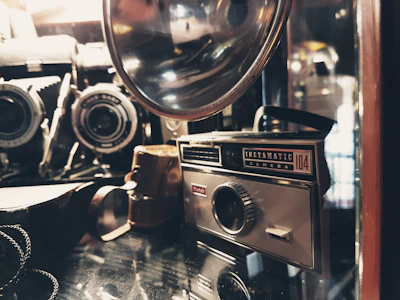 A collection of collectible cameras arranged on a rustic table with warm lighting.