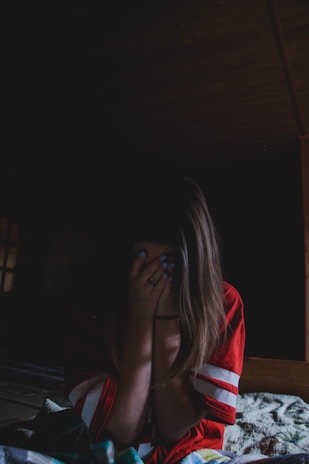 woman wearing red and shirt covering her face