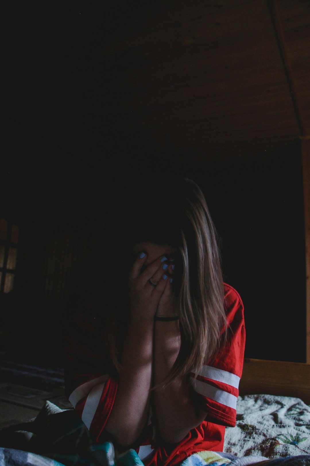 woman wearing red and shirt covering her face