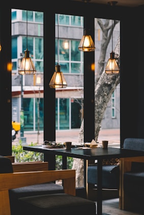 dining table and chair set under four lighted pendant lamps
