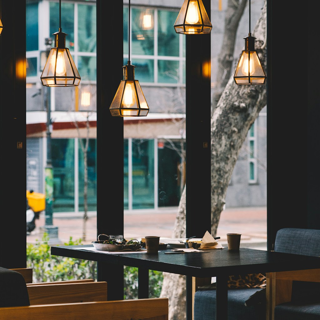 dining table and chair set under four lighted pendant lamps