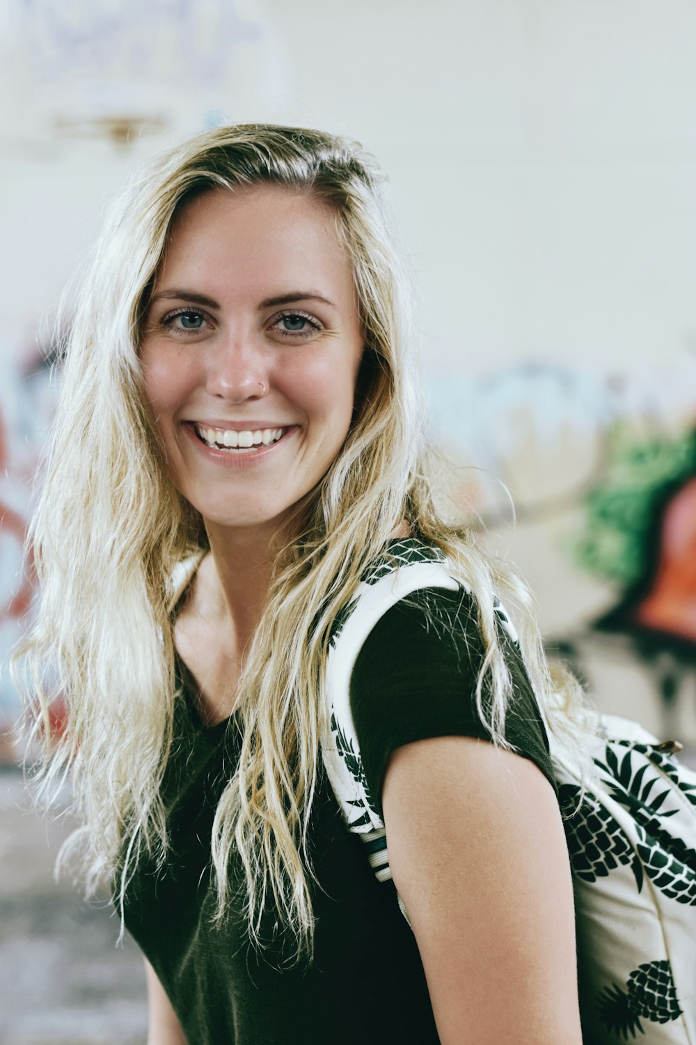 woman smiling while carrying backpack