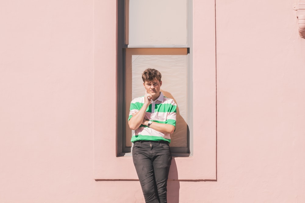 a man standing in front of a pink building