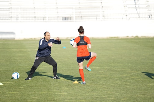 a couple of people on a field with a soccer ball
