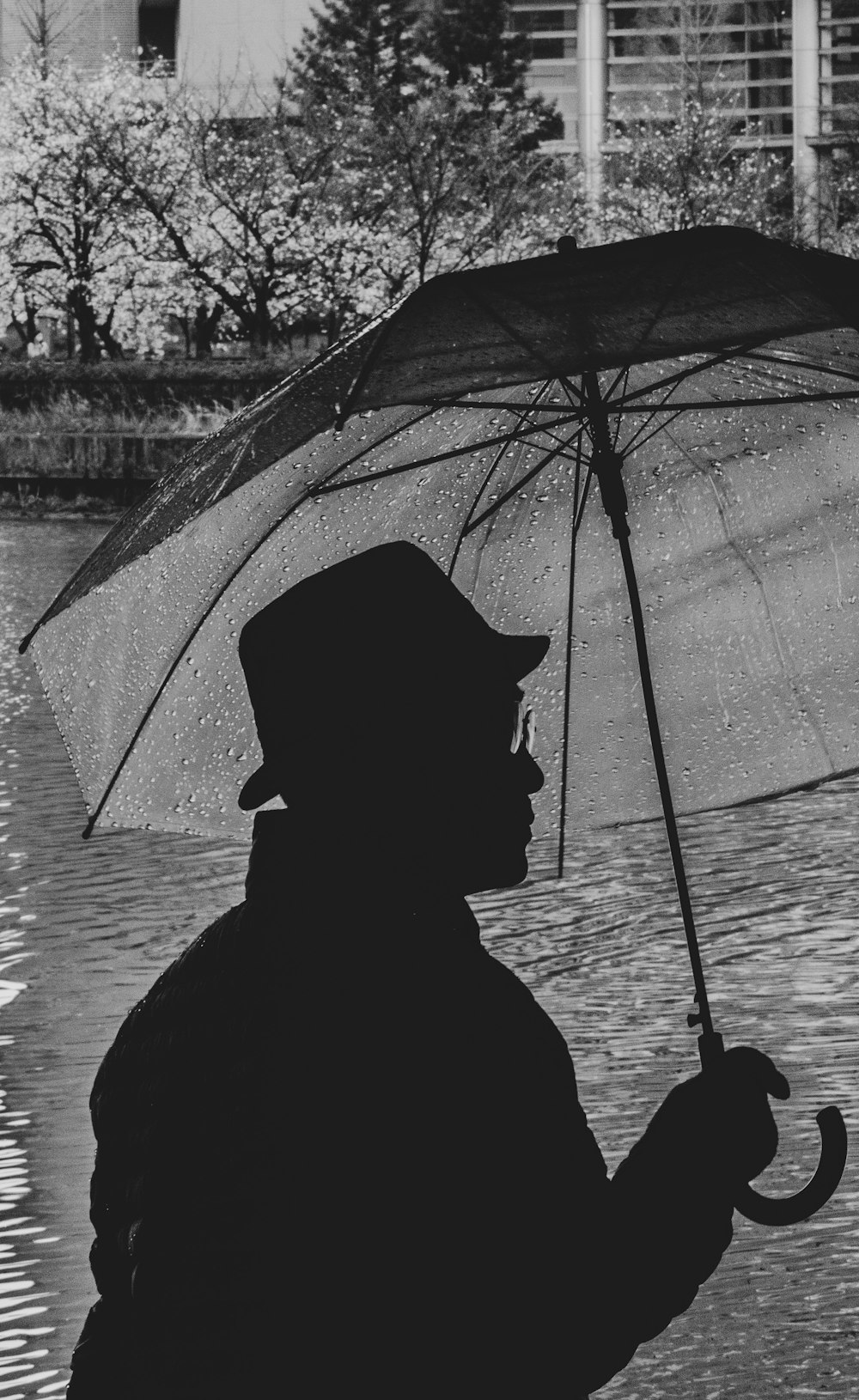 grayscale silhotte of man holding umbrella