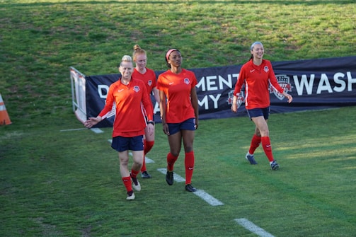 A group of friends smiling and cheering as they cross the finish line together.